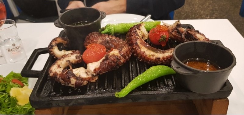 Armer av blekkspruten octopus og grønnsaker på en grillplate på Hürdeniz restaurant. Beste octopus restaurant Nord Kypros.